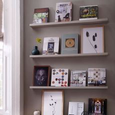 open book shelve with grey wall and wall frame