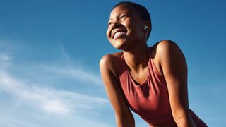 a photo of a smiling woman outside on a clear day