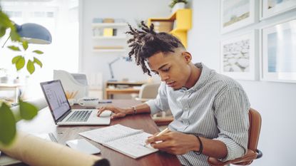 A young man works on his computer.