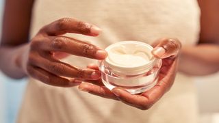 Woman holding an unmarked face cream