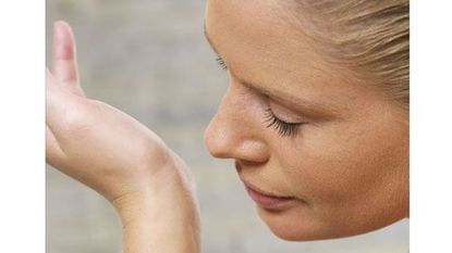 Woman Smelling Perfume on Wrist