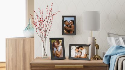 A collection of three Nixplay digital photo frames on a wall