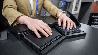 A person using AutoKeybo's numpad and trackpad after switching from its keyboard layer