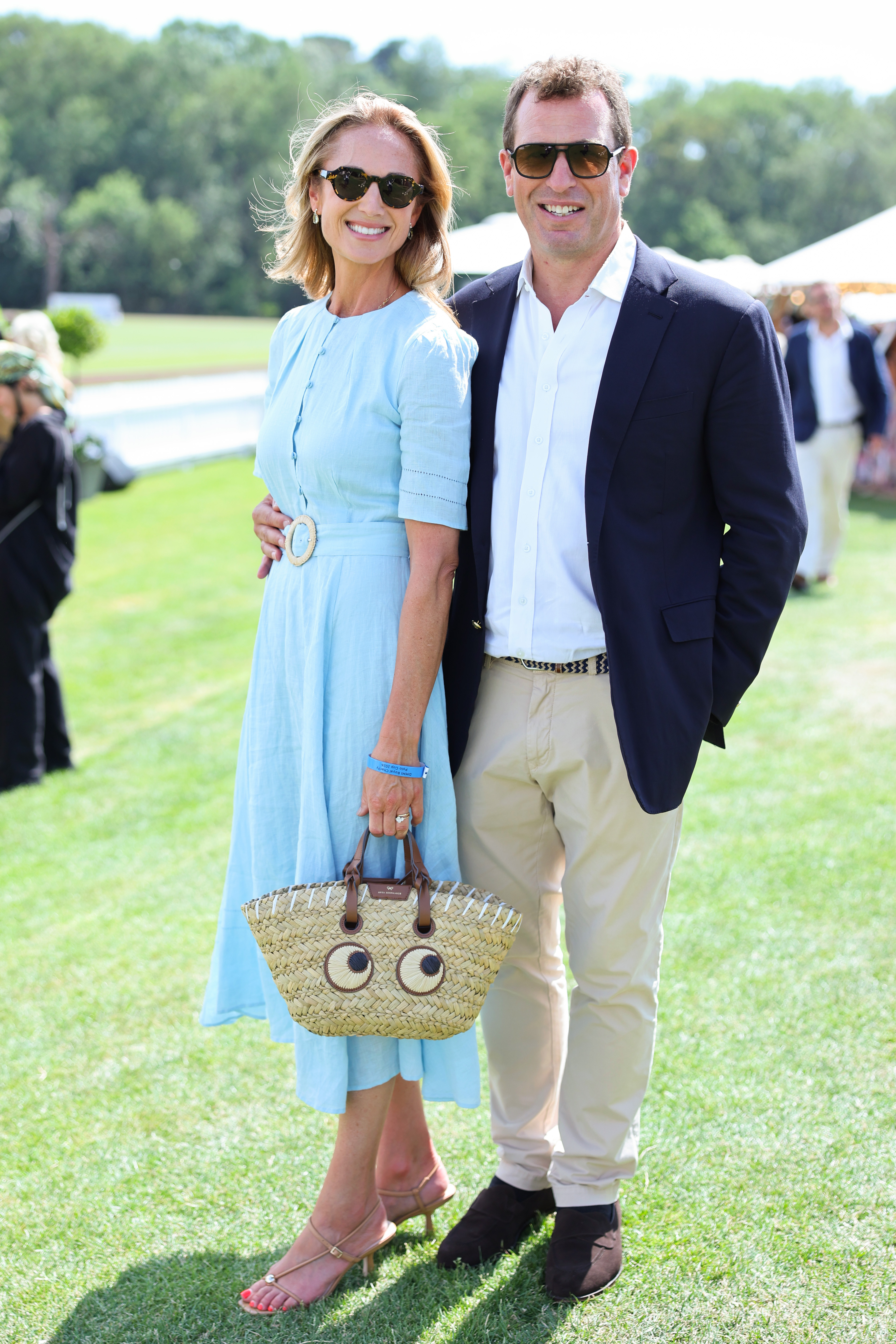 Harriet Sperling wearing a blue dress posing with Peter Phillips at a polo match