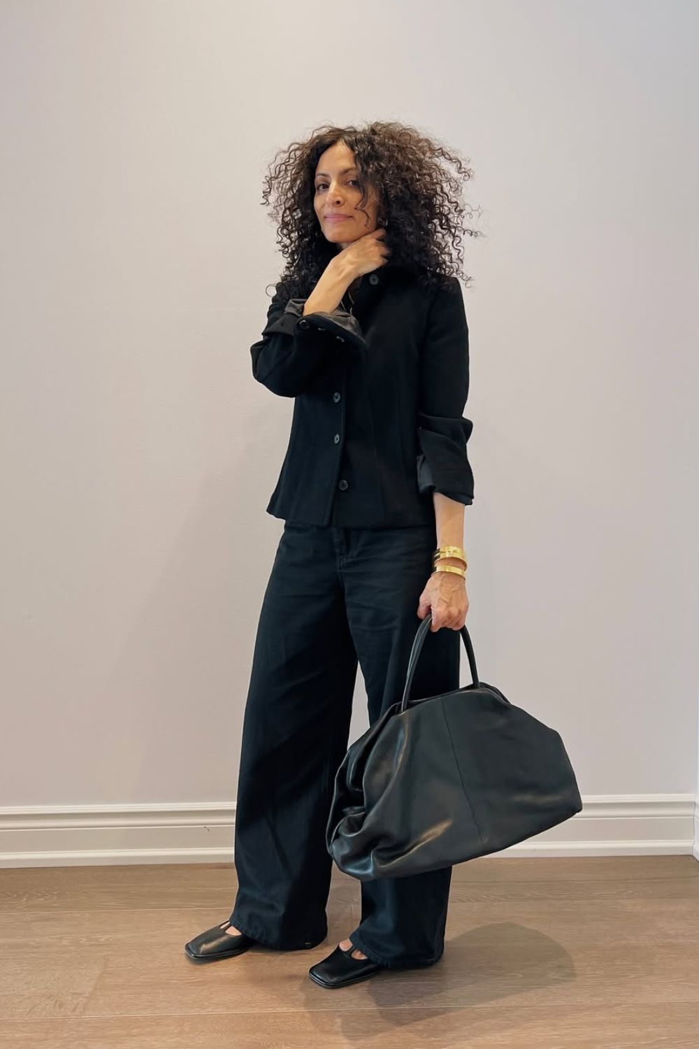 @neelam.ahooja wearing a black outfit and tote bag