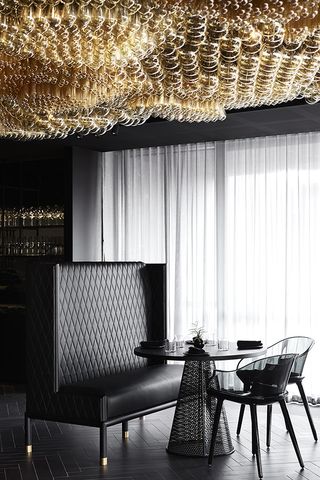 At the Mornington Peninsula's hotel, there is a black sofa, chair, and table