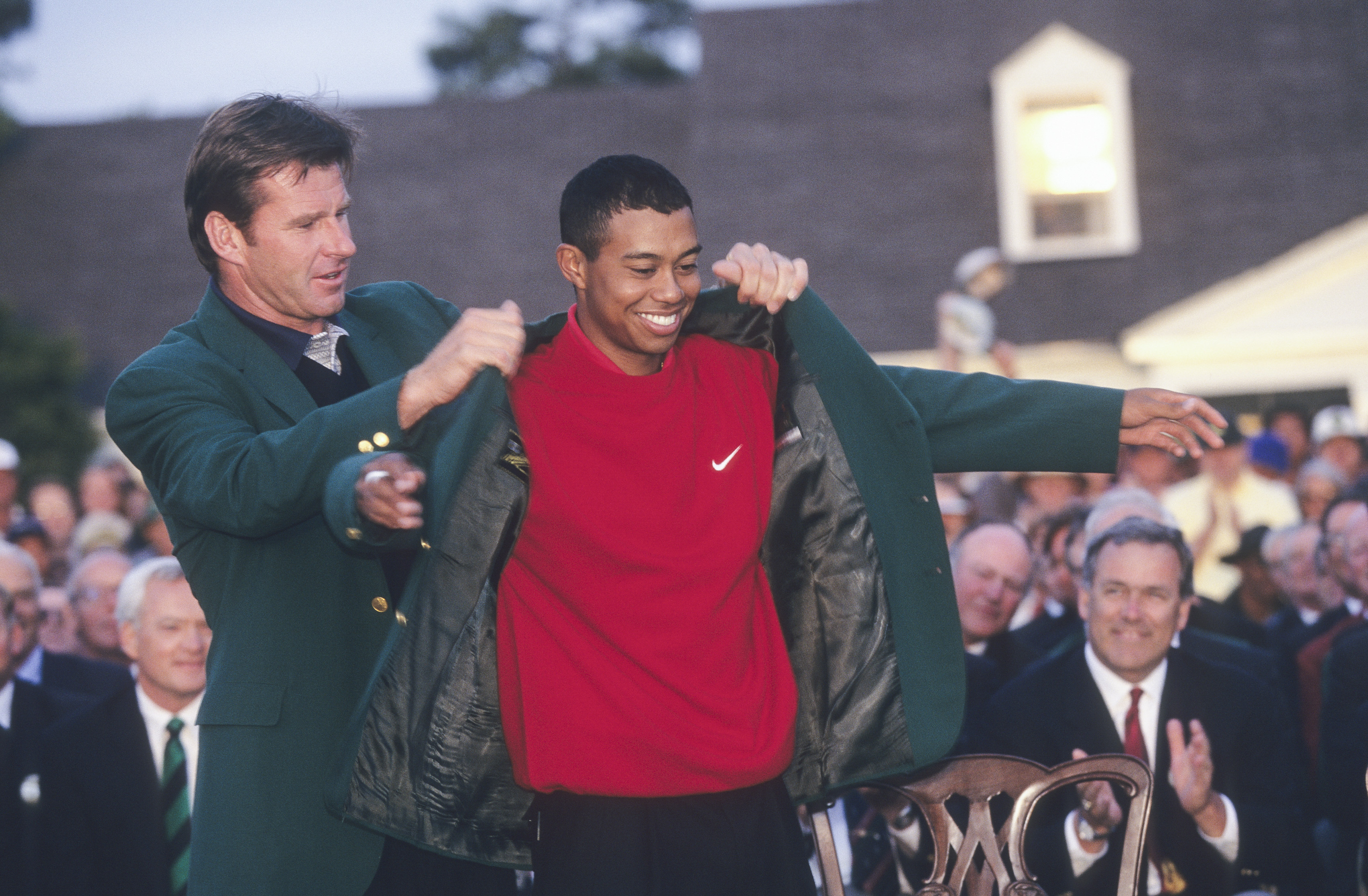 Sir Nick Faldo puts the Green Jacket on Tiger Woods at The Masters
