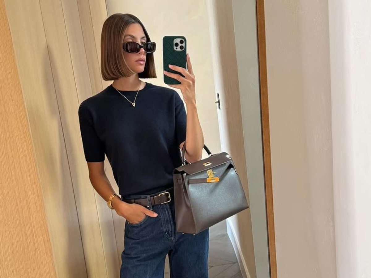 Woman wearing dark wash bootcut jeans fall 2025.