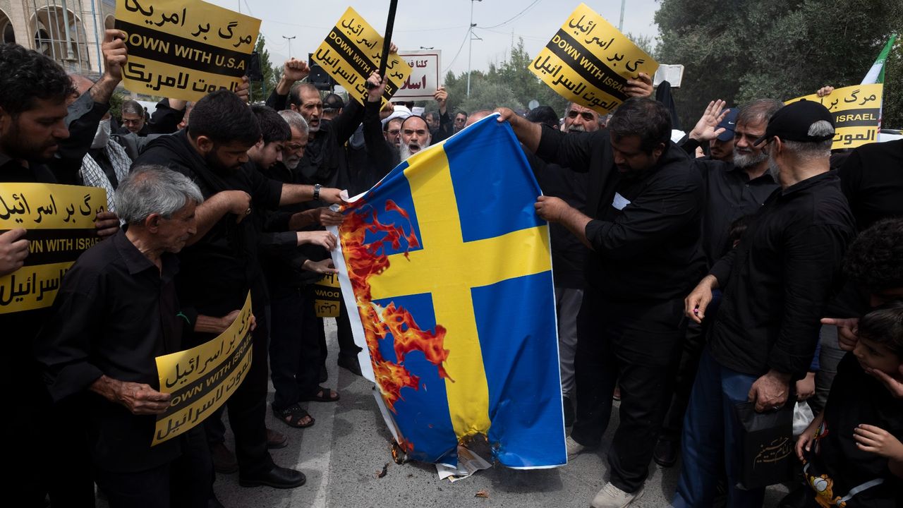 Iranian protestors burning a Swedish flag in response to a Quran burning in Stockholm in 2023