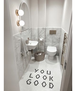Black and white bathroom with 'You look good' mosaic tiled floor by @nina_moves_in