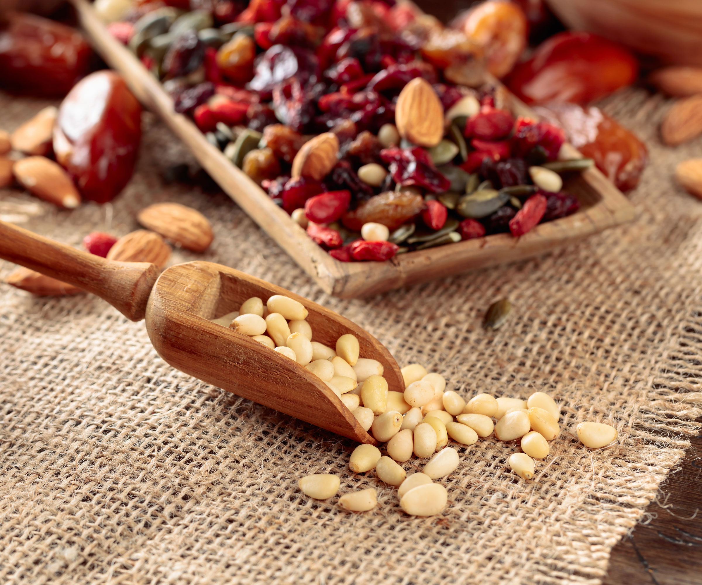 platter of dried fruit and nuts and seeds with wooden food scoop