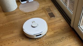 Narwal Freo X Plus robot vacuum and mop about to clean a pile of cereal from a rug