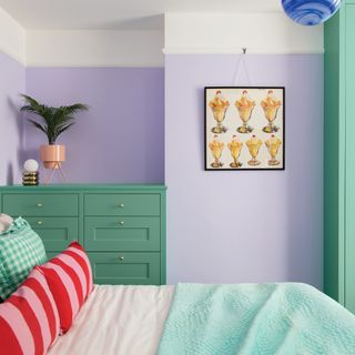Purple bedroom with green furniture and patterned cushions