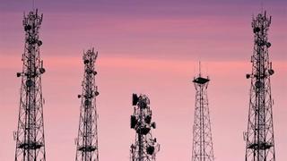 Telecommunication antenna satellite with pink and violet clouds at sunrise springtime