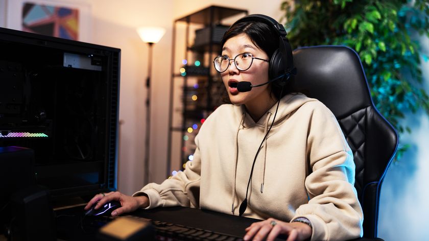 Girl with nerd glasses playing games on the computer, professional gamer sits in a comfortable chair with headphones on her ears, she is shocked, experiencing the virtual world, led lighting in room