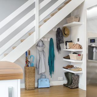 Open plan house, under stair storage with pegs, hooks, and shelving