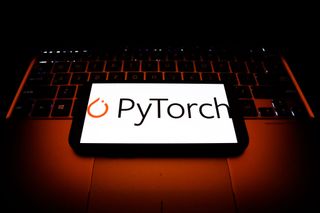 A smartphone resting on a laptop with the logo for PyTorch displayed