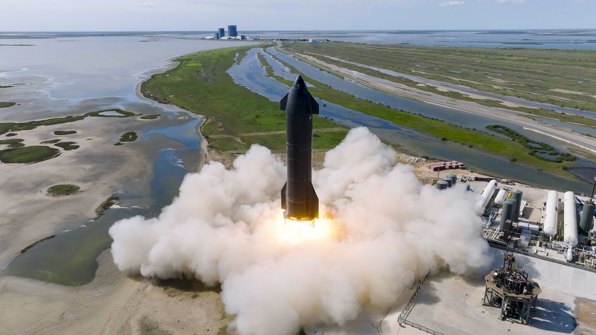 Starship with steam during a static fire test with swamp and water in behind