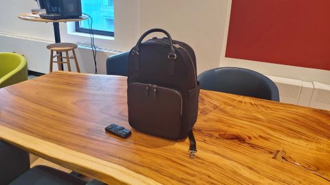 a black laptop backpack sitting on a wooden desk