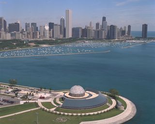 This aerial view shows Adler Planetarium's relationship to the Chicago skyline in the background.