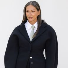 Jenna Lyons wearing her hair down and straight and wearing a button up shirt and tie with a blazer over it.