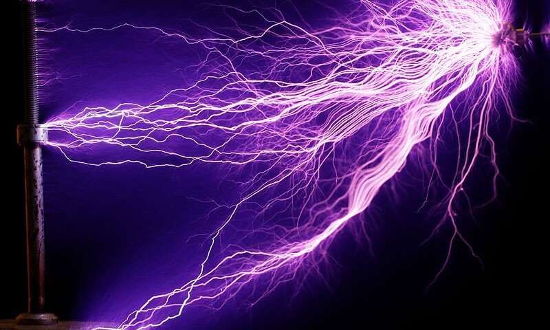 An image shows arcs of electricity generated with a Tesla coil, an earlier experiment in shooting energy across open space that unfortunately would not effectively charge your phone.