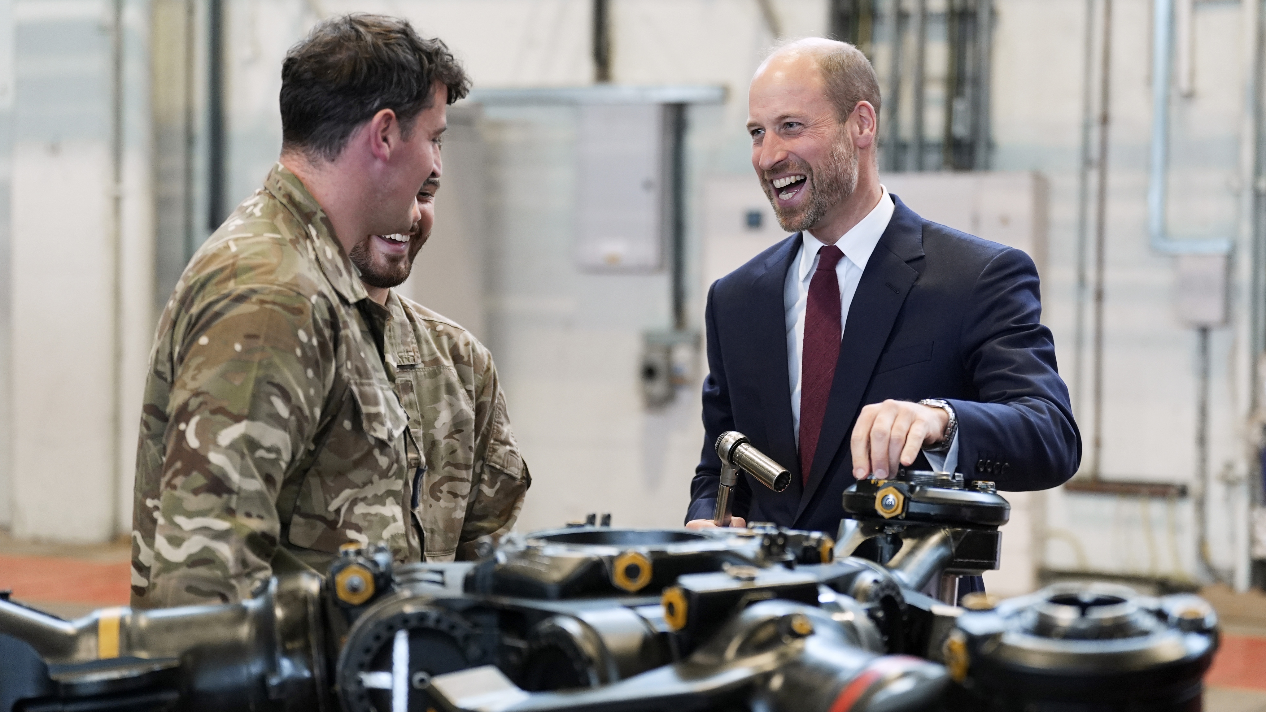 Prince William, Prince of Wales (right) helps work on a main rotor head of a Chinook helicopter as he meets helicopter technicians from No. 28 (AC) Sqn during a visit to RAF Benson on October 15, 2025