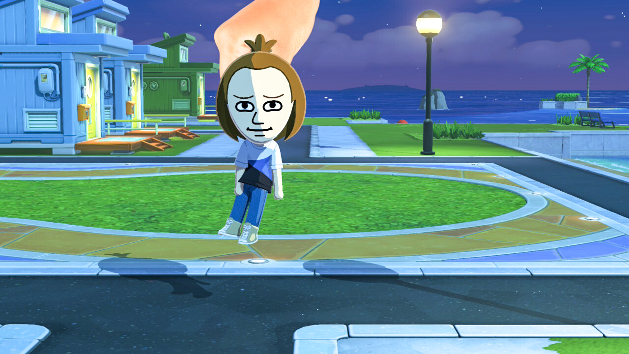A screenshot from Tomodachi Life: Living the Dream showing a hand picking up a Mii and moving them somewhere else