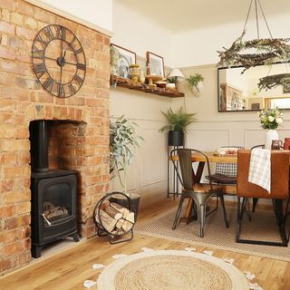 neutral dining room with brick wall and wood burner