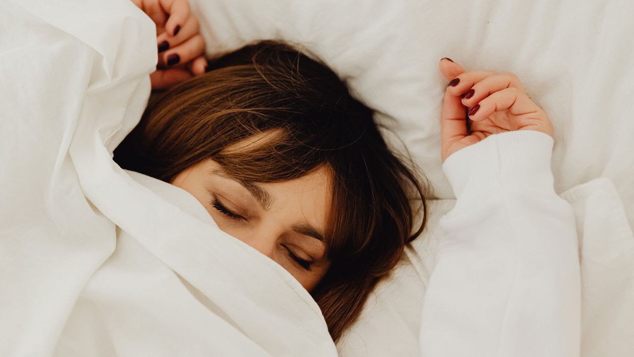 A woman asleep under a duvet