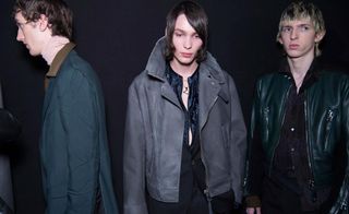 3 male models wearing outerwear look away from the camera