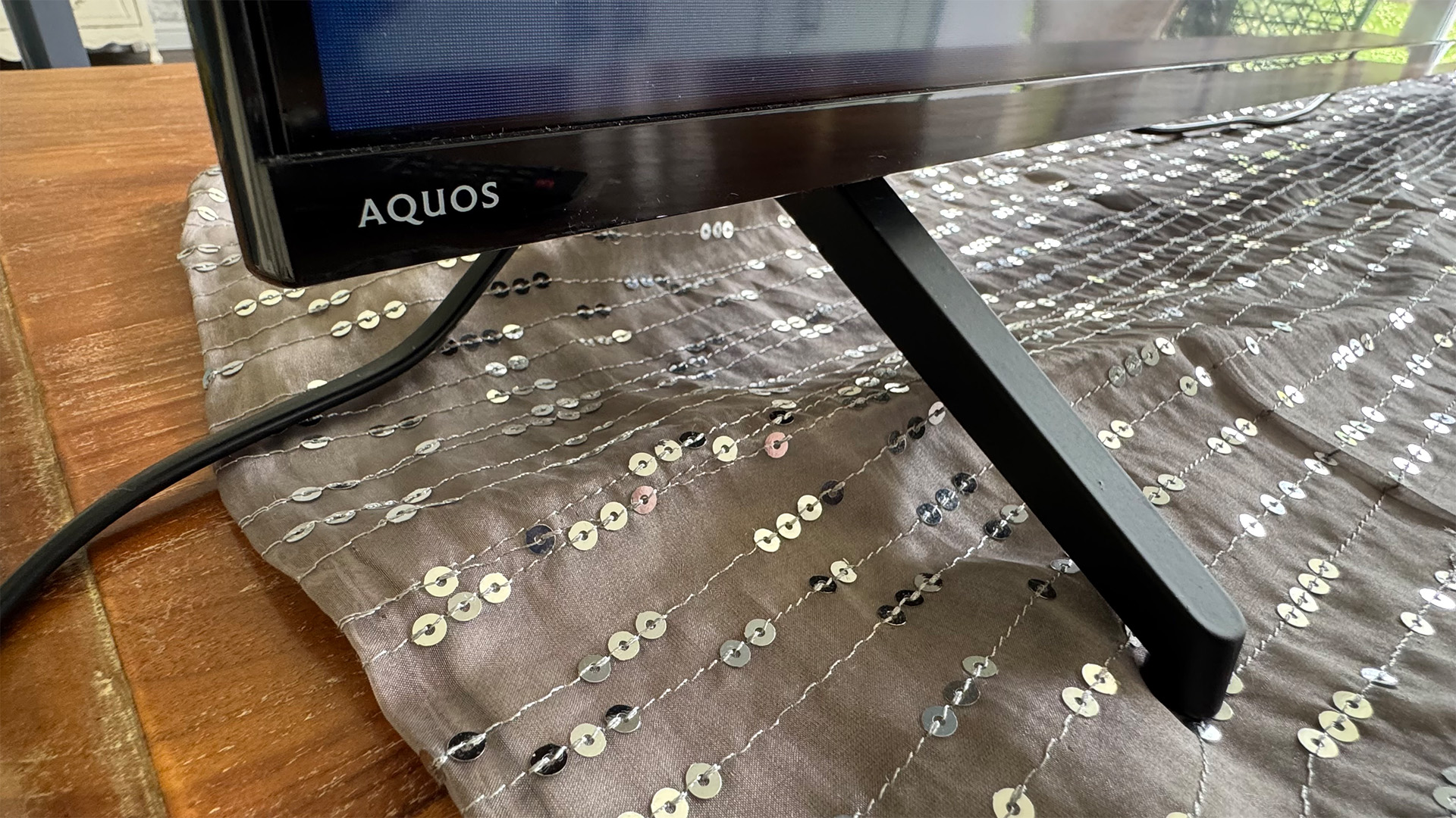 Sharp GK4245K 70-inch 4K TV close up on bottom left corner and feet, showing Aquos logo