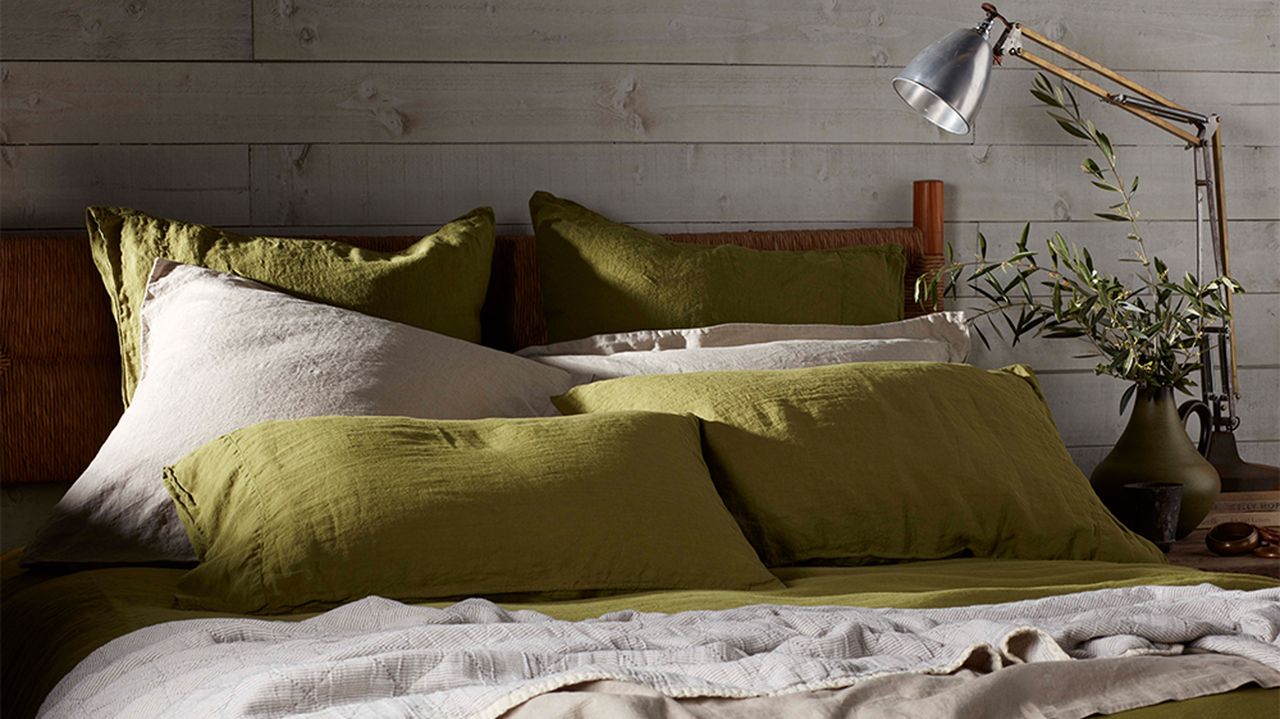 bed with green and beige linen bedding