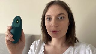 Sleep writer Ruth Jones holds a moonbird stress and relaxation device in her bedroom