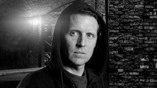 black and white image of Nathan Curtis (Chris Harper) with his hood up looking menacing in Coronation Street