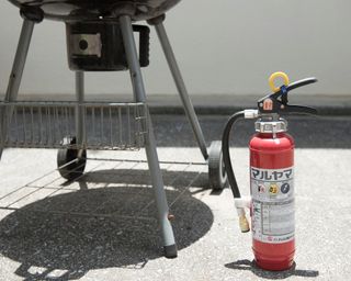 fire extinguisher next to a barbecue