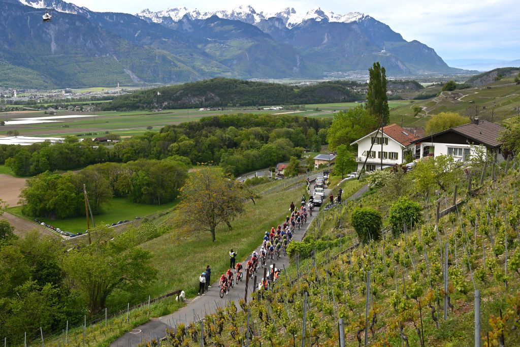 LEYSIN SWITZERLAND APRIL 27 Egan Bernal of Colombia Carlos Rodriguez of Spain and Team INEOS Grenadiers Juan Ayuso of Spain and UAE Team Emirates Yellow Leader Jersey Ilan Van Wilder of Belgium and Team Soudal QuickStep White Best Young Rider Jersey and a general view of the peloton passing Aigle village 405m during the 77th Tour De Romandie 2024 Stage 4 a 1592km stage from Saillon to Leysin 1314m UCIWT on April 27 2024 in Leysin Switzerland Photo by Luc ClaessenGetty Images