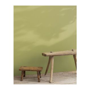 green paint color on wall with wooden stool in front