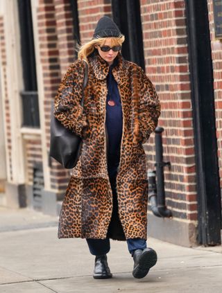 Jennifer Lawrence in New York City wearing weatherproof boots with a leopard coat trend and jeans