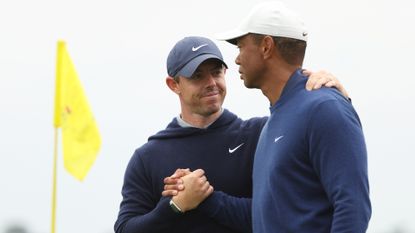 Rory McIlroy of Northern Ireland shakes hands with Tiger Woods of the United States on the 18th green after they completed a practice round prior to the 2023 Masters Tournament