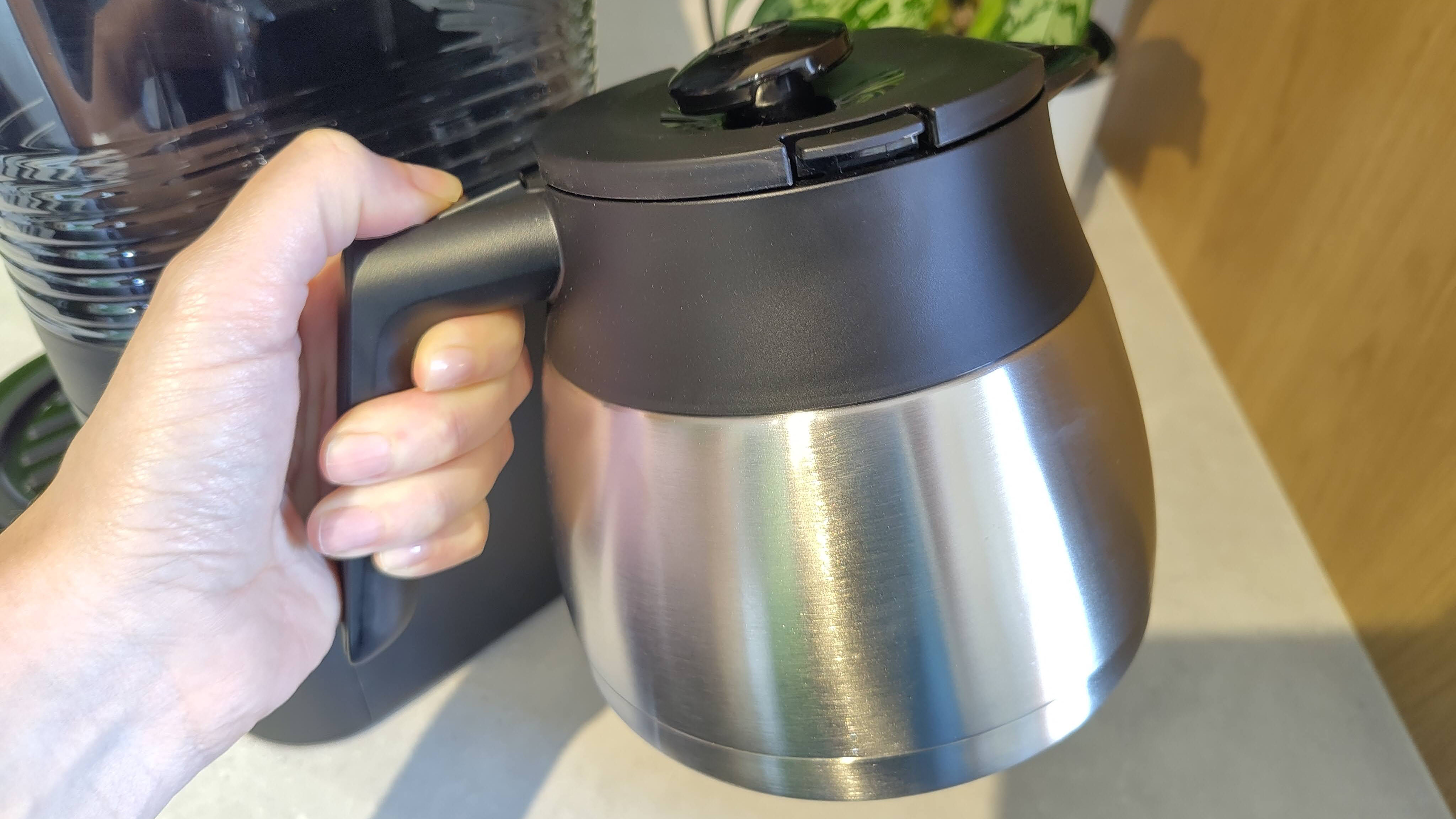 Person's hand holding carafe for Melitta AromaFresh Pro Therm coffee maker