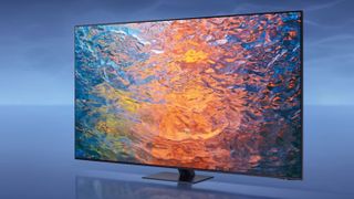 The Samsung S90C TV in a blue room, with an image of rippling liquid on the screen