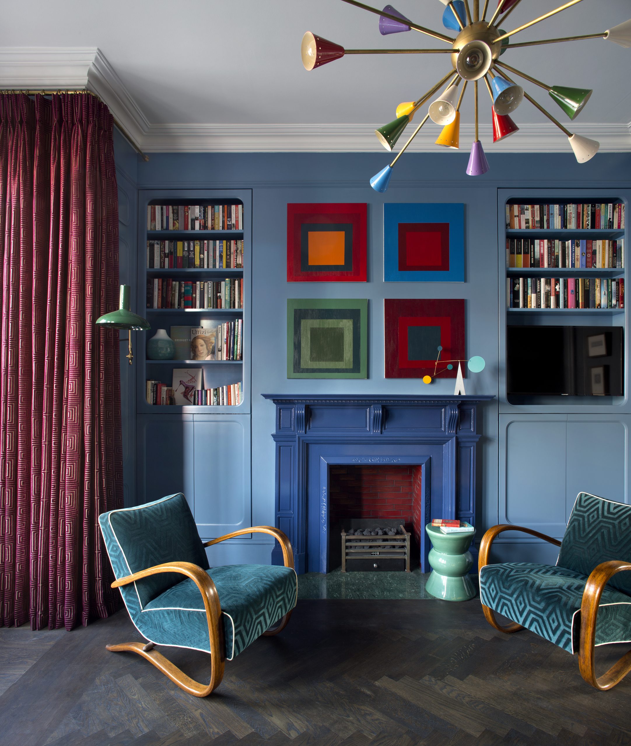 Small blue living room with built in shelving and small TV