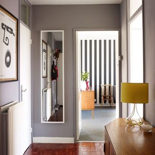 hallway with grey wall and mirror on wall