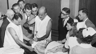 Dr. Walter Freeman performs a lobotomy using an instrument like an ice pick which he invented for the procedure. Inserting the instrument under the upper eyelid of the patient, Dr. Freeman cuts nerve connections in the front part of the brain.