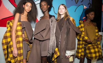 Far left, model is seen wearing a fallen fold crop top and matching felt skirt. She holds a checkered coat. Middle, models can be seen wearing similar felt fold tops and satin outerwear. Right, model wears matching checkered skirt, top, coat and bag.
