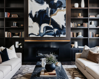 Apartment living room with large bespoke open shelving, marbled contemporary art and light colored couches