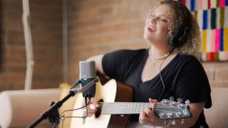 Woman singing and playing guitar with the AKG Ara