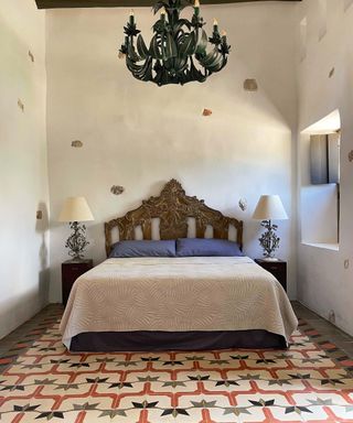 Mexican decor bedroom with dark framed bed and chandelier