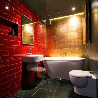 batroom with red wall and bathtub